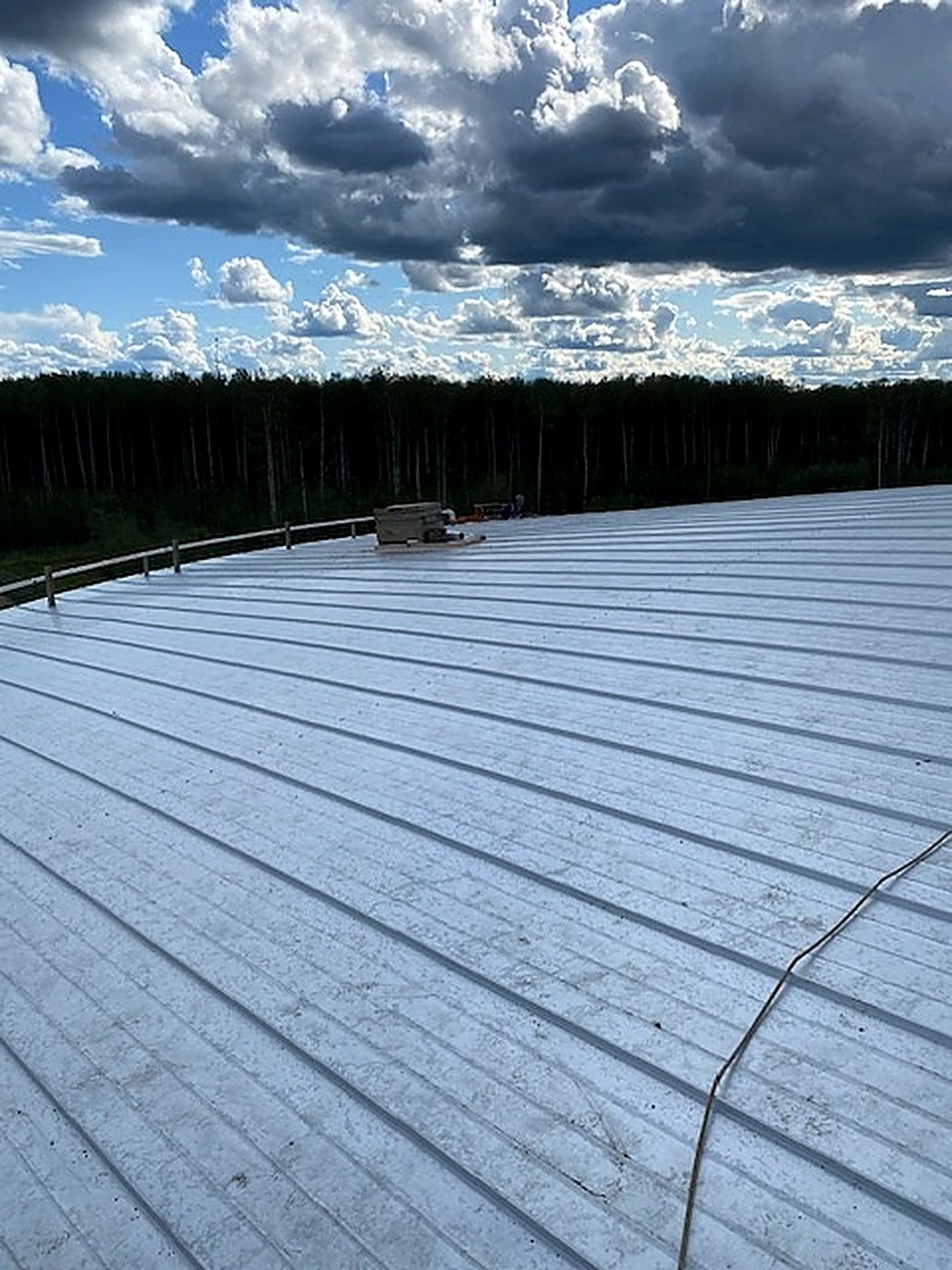 Finished standing-seam roof panels running continuous from centre to eave