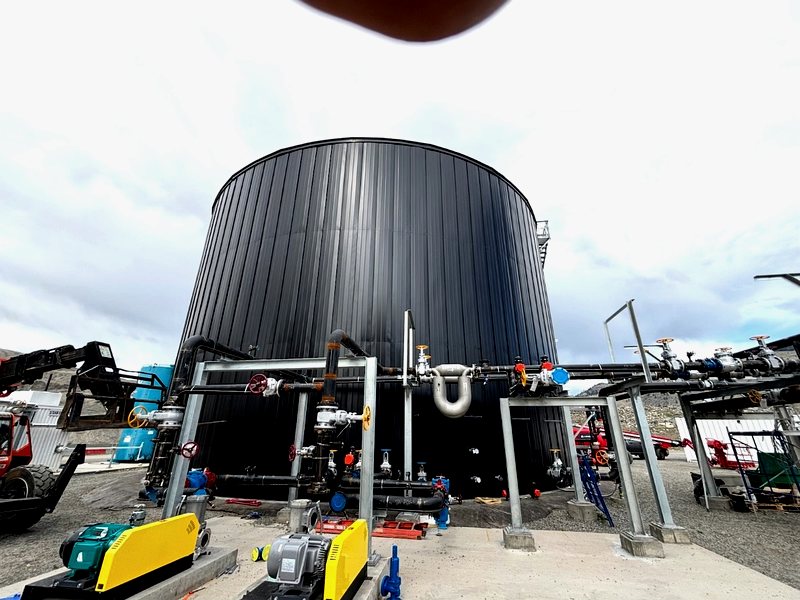Large dark insulated tank at industrial site